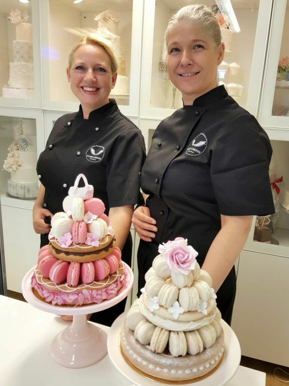 Kate Kippersund og Elisabeth Vikøren med to eksemplarer av den nye kaken, Flying Macaron Rings.