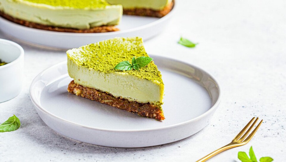 Raw vegan matcha cheesecake on a gray plate.