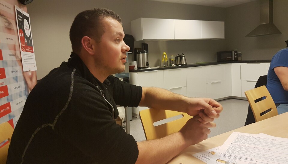 Erik Stangeland er utdannet diplombaker og jobber nå som organisasjonsarbeider i NNN Rogaland. Erik Stangeland, som jobber i NNN Rogaland, sitter ved et bord og snakker med ansatte på en arbeidsplass.