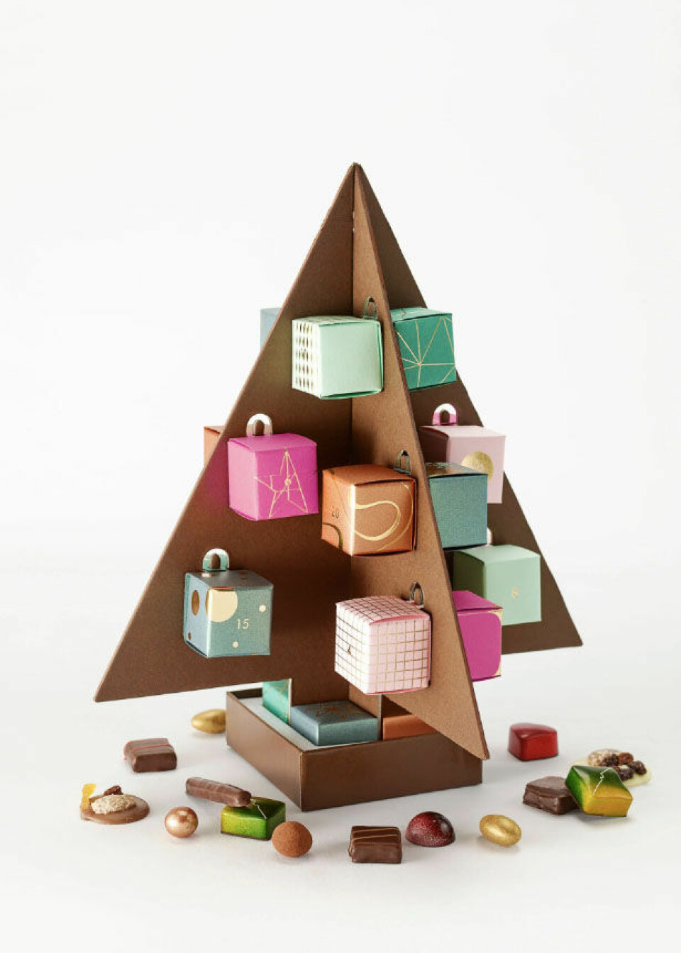 Julekalender i papp formet som et tre med små pakker med sjokolade som henger på.