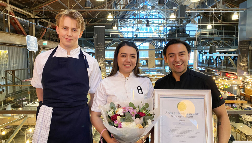 Kjøkkensjef Jørgen Breievne, daglig leder Fabian Franco og medeier Brenda Jensen er glade for prisen som Årets glutenfrie bedrift i kategorien serveringssteder. To menn og en dame der den ene holder en diplom i glass og ramme.