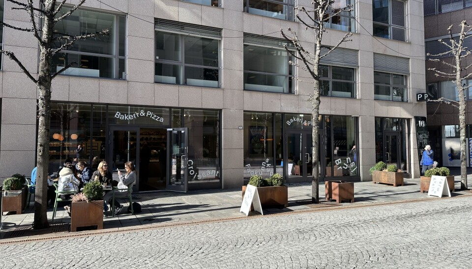 Kveitemjøl på Aker Brygge har fått ny profil. Hovedskiltet på fasaden er ikke kommet på plass ennå. Avstandsbilde av bakeriet på første etasje som viser et fireetasjers kontorbygg.