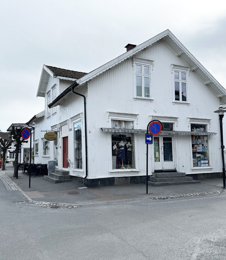 Hvitt gammel hus med gaster på begge sider.