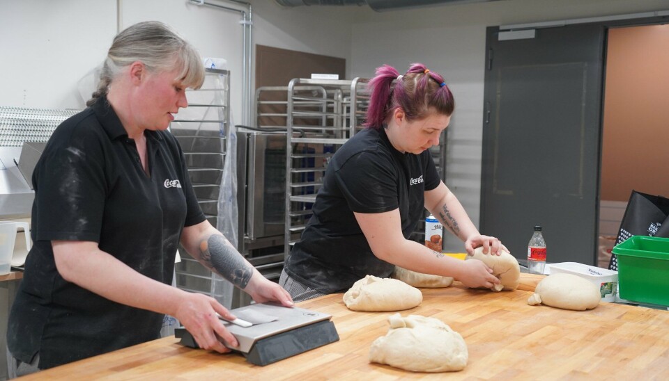Anja Christensen og lillesøster Kristine Christensen har nok å gjøre i bakeriet på Lura. Her baker de skoleboller. To jenter som står og jobber ved et bakebord i et bakeri.
