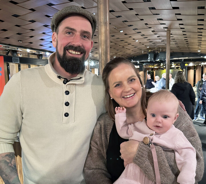 Roger Waagan Flemsæterhaug og Anne Flemsæterhaug Waagan med minstejenta Ella trives med å jobbe sammen i familiebakeriet på Tynset. Smilende par med baby på armen.