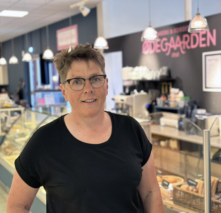 Anne Gunn Viken er daglig leder i Ødegaarden Bakeri & Konditori AS. Dame med biller i svart T-skjorte foran bakeriutsalg.