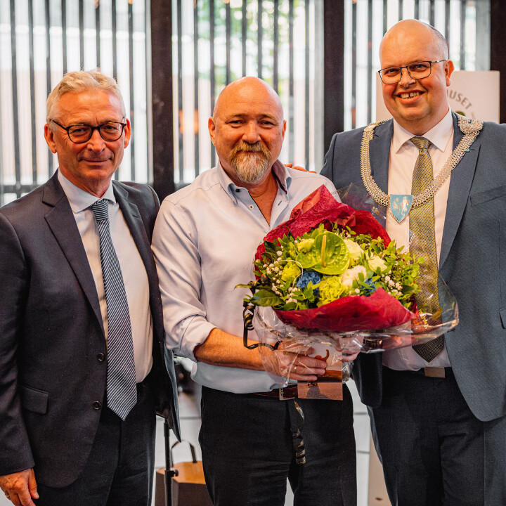 Ordfører Sigurd Reksnes (Sp) overrakte blomster til bakerisjef Lars Leite (midten) på bakeriets 100-årsmarkering. Her også sammen med Leif Petter Tunold.