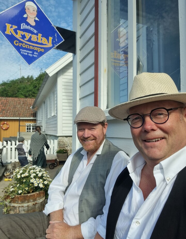 Hans Inge Justnes (til venstre) og Rune Vindsetmo i Edgars Bakeri kledt i tidsriktige klær utenfor bakeriutsalget under Farmen Kjendis-innspillingen.