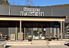 Fasaden til Stompen Bakery med skilt, glassdør og uteservering foran bygningen.
