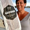 Nærbilde av en pose med Gårdsbrød fra Tine Meierier holdt foran en smilende kvinne.