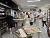 En gruppe bakere i gang med brødbaking i et profesjonelt bakeri.