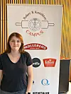 Kvinne står ved siden av et banner med Baker & Konditor Campus og flere logoer.