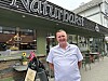 En mann står foran restauranten Naturbark med uteservering og norsk flagg.