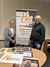 Peder Heimland og Lidia Didriksen står ved en Hev-plakat og brosjyrer på et møte i Ålesund.