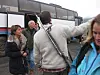 Mennesker samlet ved en turbuss, med en person i grå genser i sentrum.